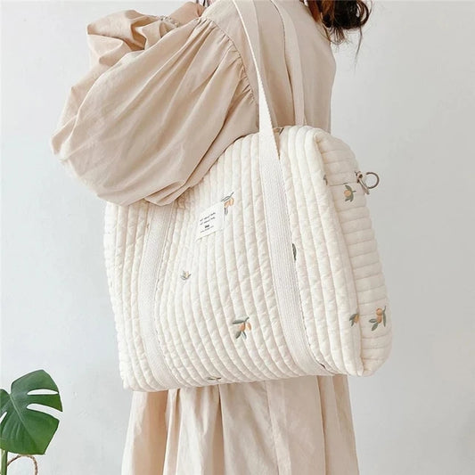 Cream embroidered quilted changing bag with shoulder strap